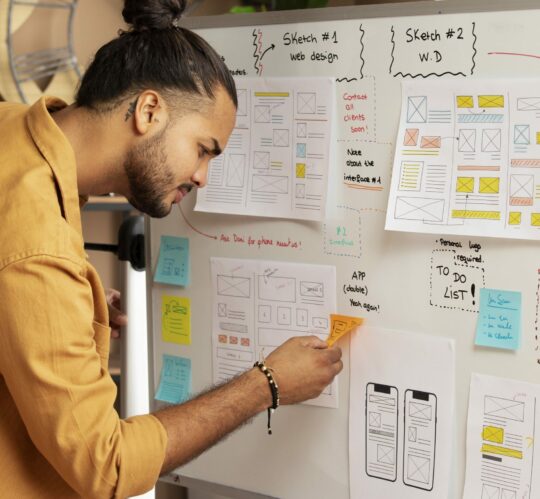 vue-laterale-homme-travaillant-avec-tableau-blanc (1)